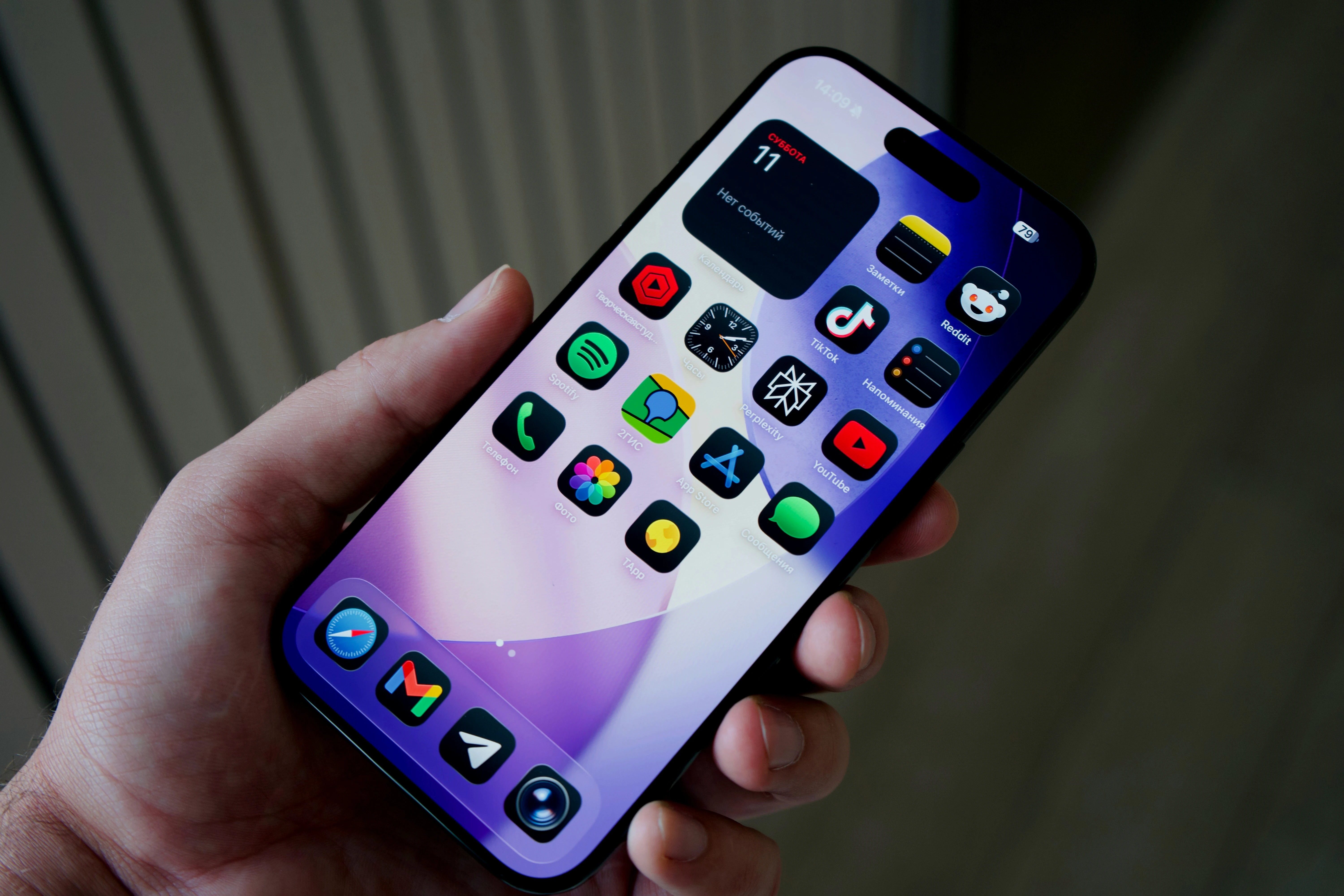 Hand holding a smartphone with colorful app icons